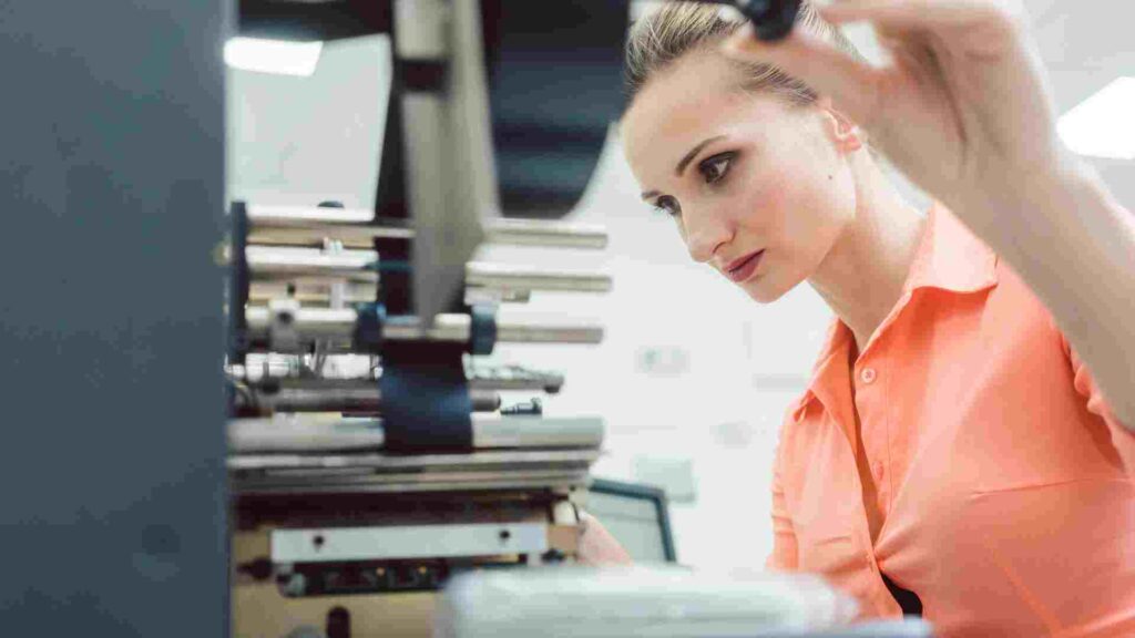 A printing service franchise employee checking the printing machine